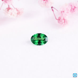 Oval cut gemstone with gemstone green hue.
