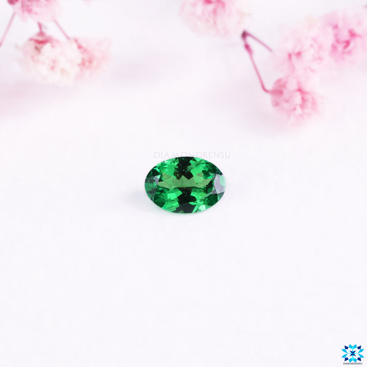 Oval cut gemstone with gemstone green hue.
