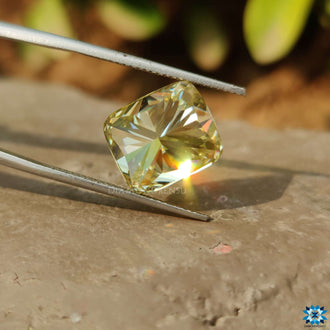 Greenish Yellow Cushion Cut shown as a single moissanite stone.
