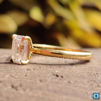 Moissanite emerald cut ring with a minimalist solitaire setting.
