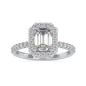 Step cut emerald with a diamond halo in a handmade ring.