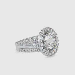 Oval halo engagement ring featuring a split shank and pave setting.
