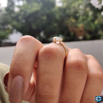 A contemporary yellow gold ring with a 2-carat hidden halo and a pear-shaped engagement stone.