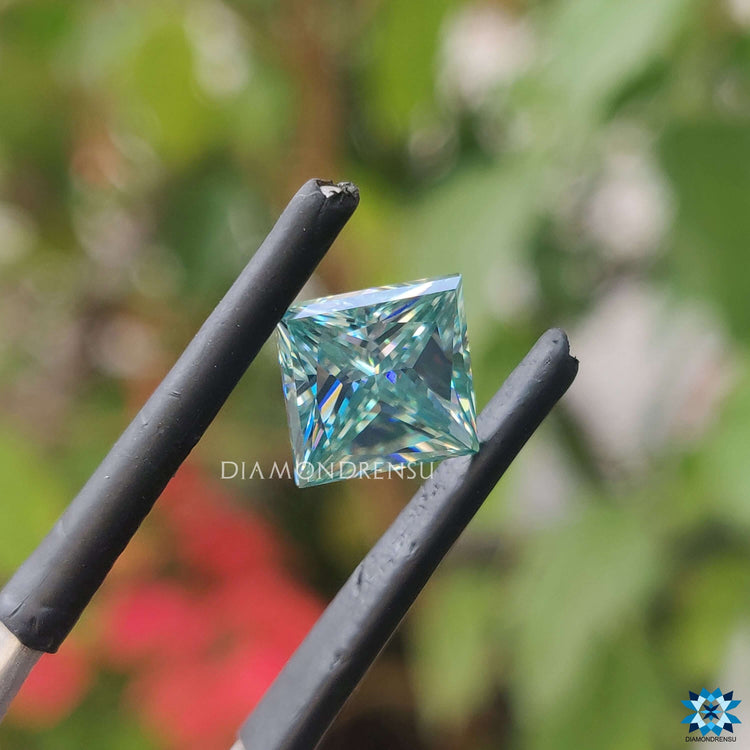 Cyan blue moissanite shaped in princess cut moissanite and listed as loose stone.
