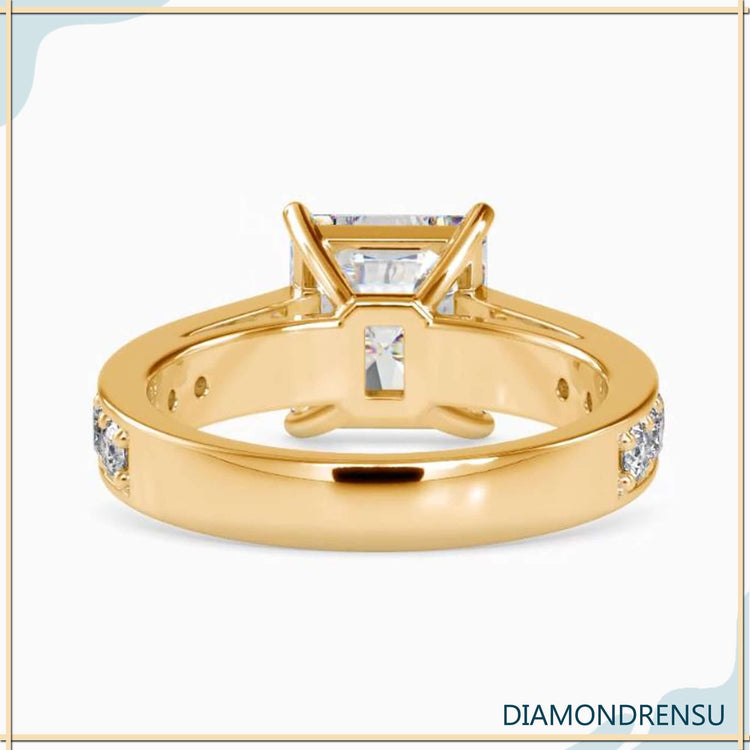 A cathedral ring setting in white gold holding a brilliant radiant cut moissanite engagement ring.