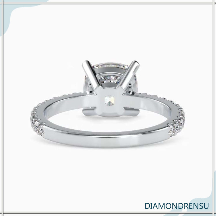 Four prong ring with cushion cut diamond and pave setting ring design.
