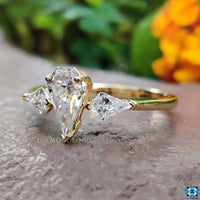 The kite cut moissanite side stones add a bold, modern twist to the design.
