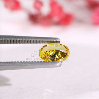 A 0.71 carat oval diamond in vivid yellow lab grown style.
