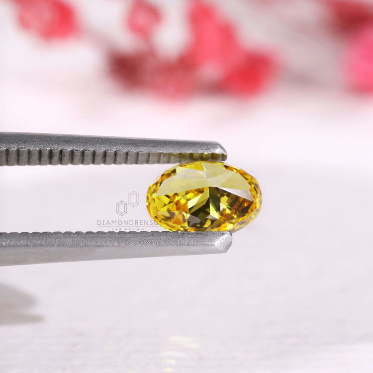 A 0.71 carat oval diamond in vivid yellow lab grown style.
