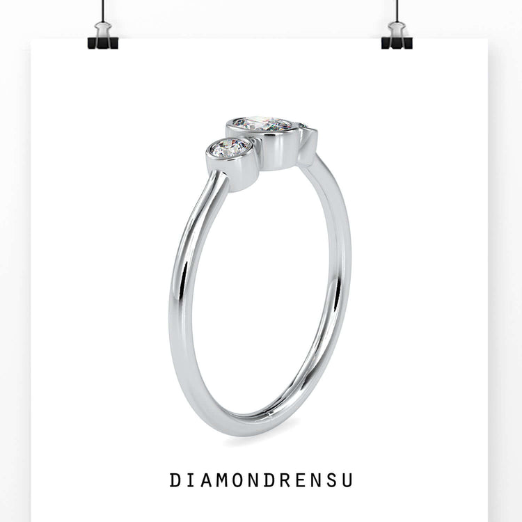 Side stone engagement ring with oval diamond in yellow gold
