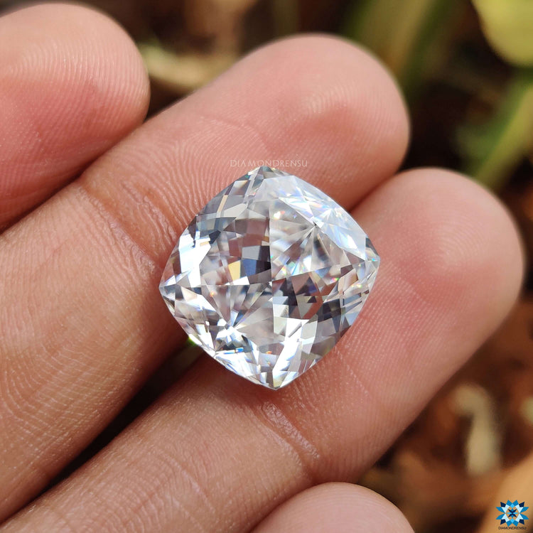 Loose moissanite stone rests above moissanite loose stones.
