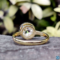 Bezel ring setting with a classic round moissanite gemstone.