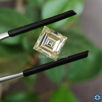 Loose moissanite stone next to 2.2 carat moissanite.
