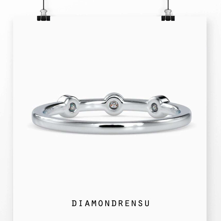 Three stone bezel ring with round diamonds in a yellow gold band
