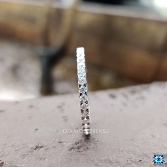 Round wedding band designed with sparkling moissanite stones.