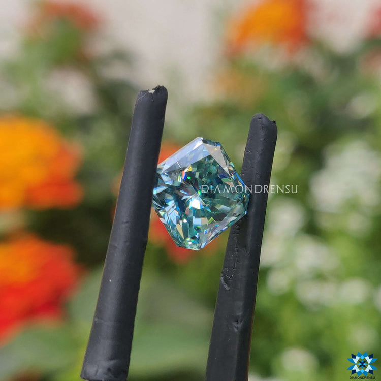 Cyan blue moissanite shaped as radiant cut and offered as loose stone.
