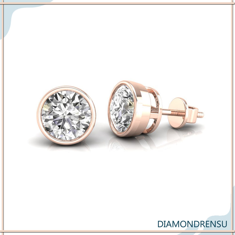 Gold bezel earrings with round diamonds for a modern and elegant finish.
