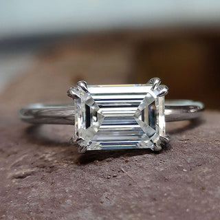Moissanite solitaire engagement ring featuring a brilliant emerald cut design.

