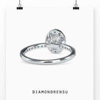 Oval diamond ring with halo and a 4 prong setting, crafted with handmade jewelry techniques.
