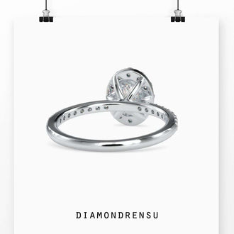 Oval diamond ring with halo and a 4 prong setting, crafted with handmade jewelry techniques.
