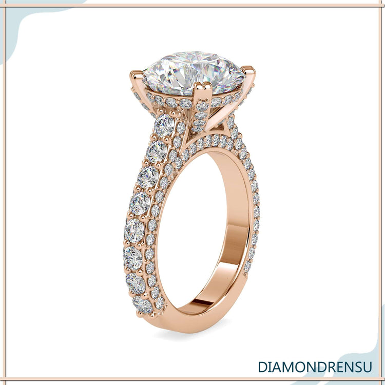 Hidden halo engagement ring with a round diamond and side stones.
