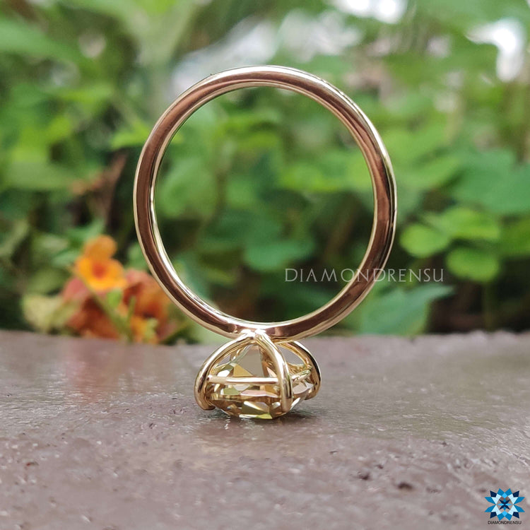 Stunning gold solitaire engagement ring with a cushion-cut moissanite, perfect for special occasions.