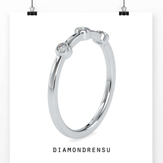 Round diamond wedding band in yellow gold with a bezel setting
