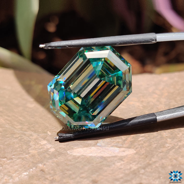 Moissanite emerald cut featured as 26 carat moissanite in cyan blue moissanite.
