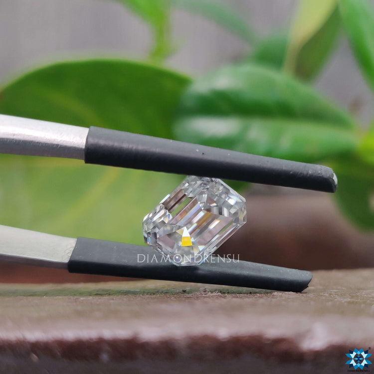 Emerald cut 2.04 carat shown in near colorless gray and loose moissanite.
