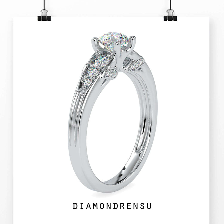 Round diamond engagement ring with side stones and a tapered band.
